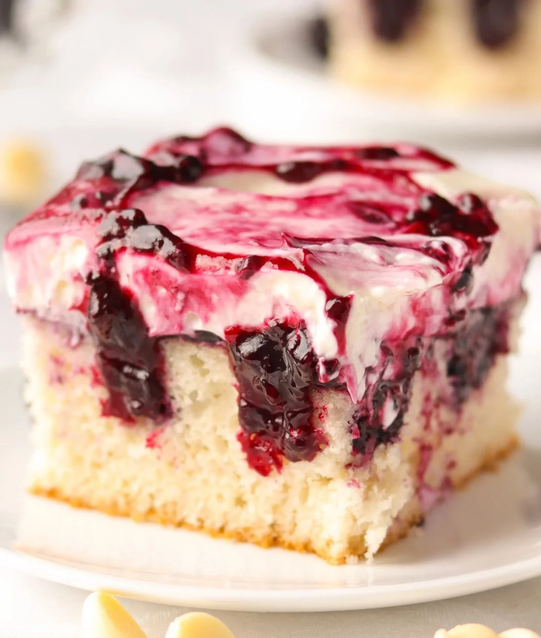 Delicious White Chocolate Blackberry Poke Cake topped with fresh blackberries.