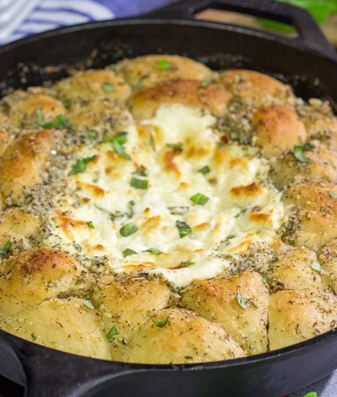 Delicious white pizza dip served in a bowl with fresh herbs and breadsticks.