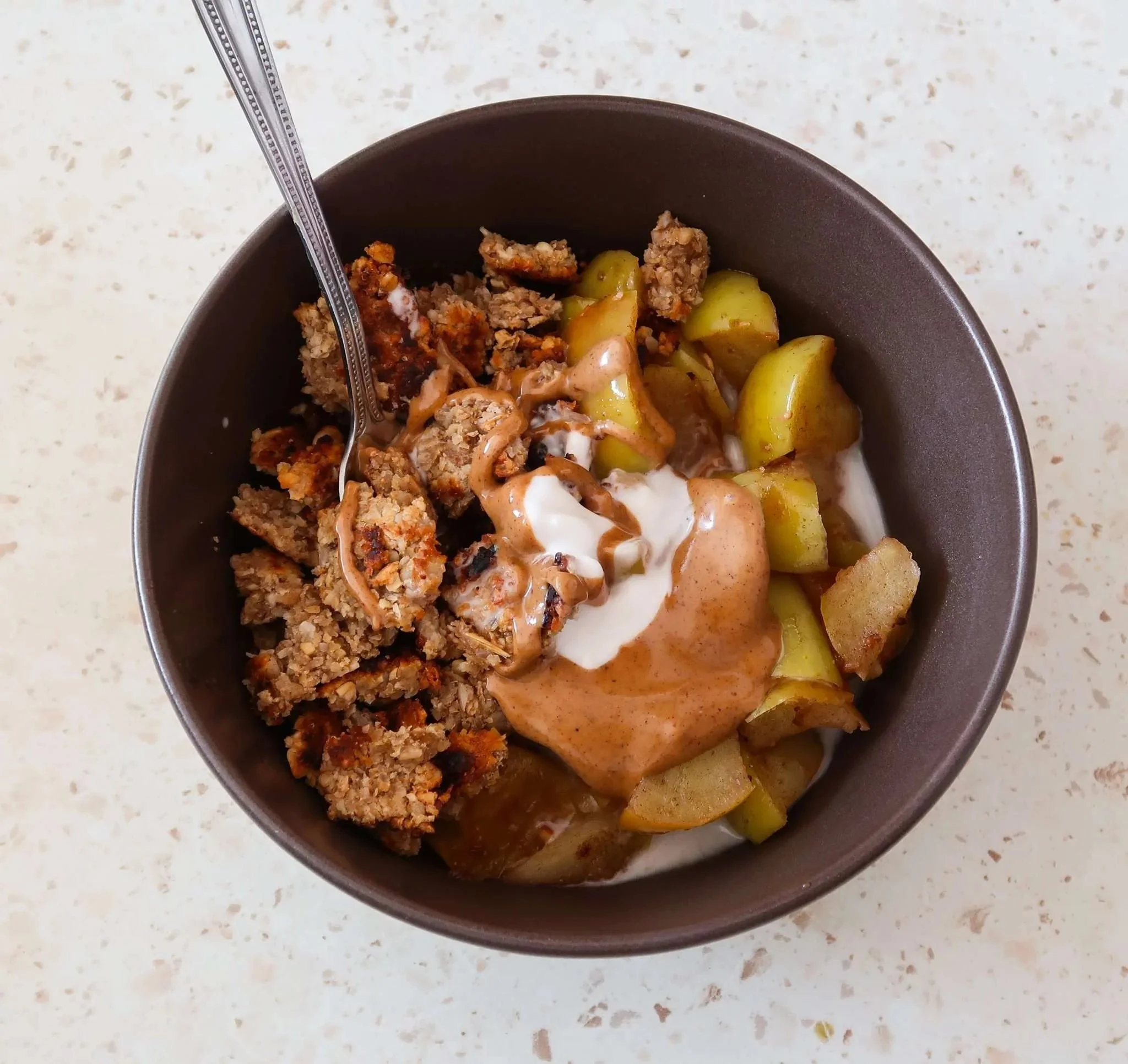 Healthy stovetop apple crumble served in a bowl with cinnamon and oats