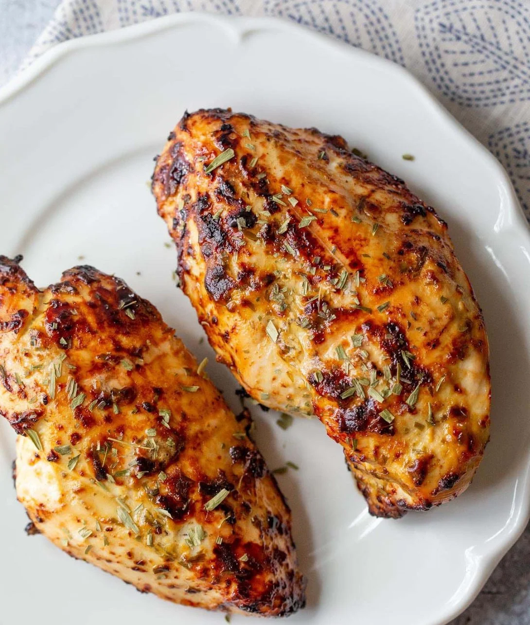Air Fryer Honey Dijon Chicken Breasts garnished with herbs on a plate