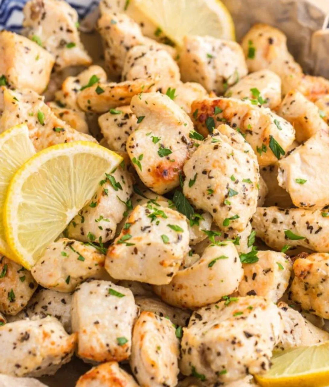 Air Fryer Lemon Chicken Bites served on a plate with fresh herbs