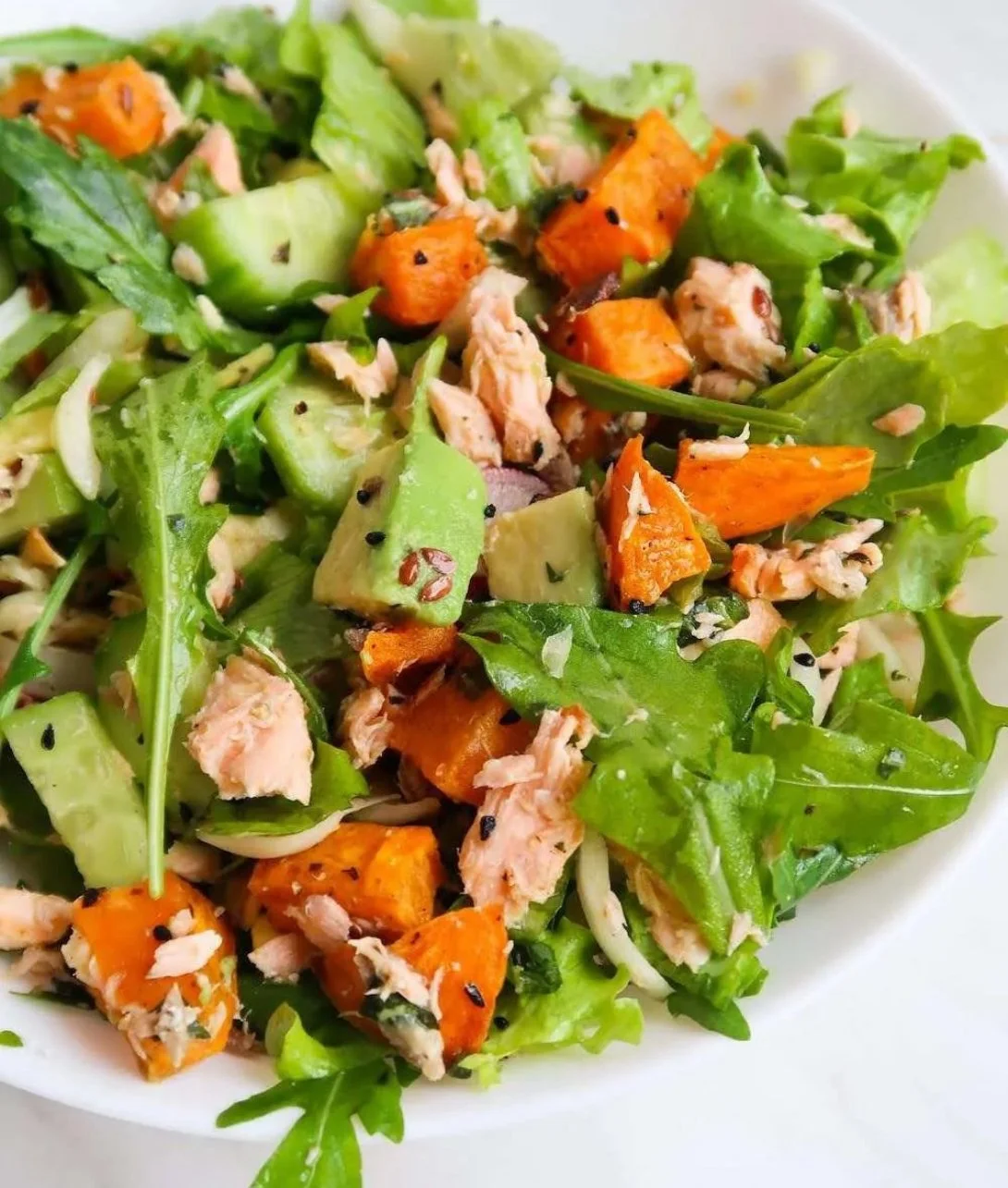 Vibrant anti-inflammatory salmon salad with fresh vegetables and dressing.