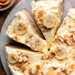 Deliciously layered Banana Pudding Cheesecake with bananas and whipped cream.