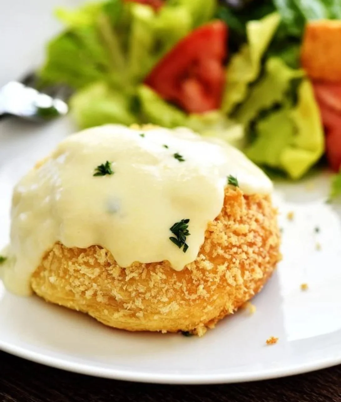 Delicious chicken pillows with creamy Parmesan sauce served on a white plate