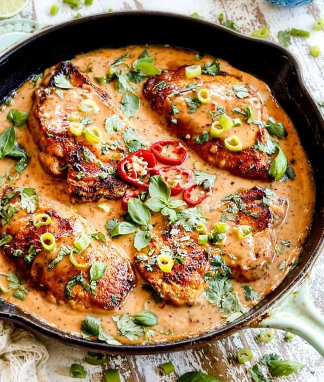 Plate of Coconut Chicken served with rice and garnished with fresh herbs