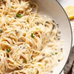 Delicious creamy lemon caper pasta garnished with fresh herbs