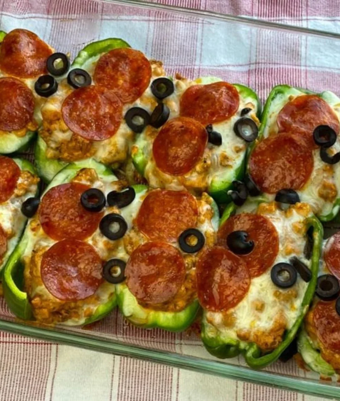 Creamy pizza stuffed bell peppers topped with cheese and herbs