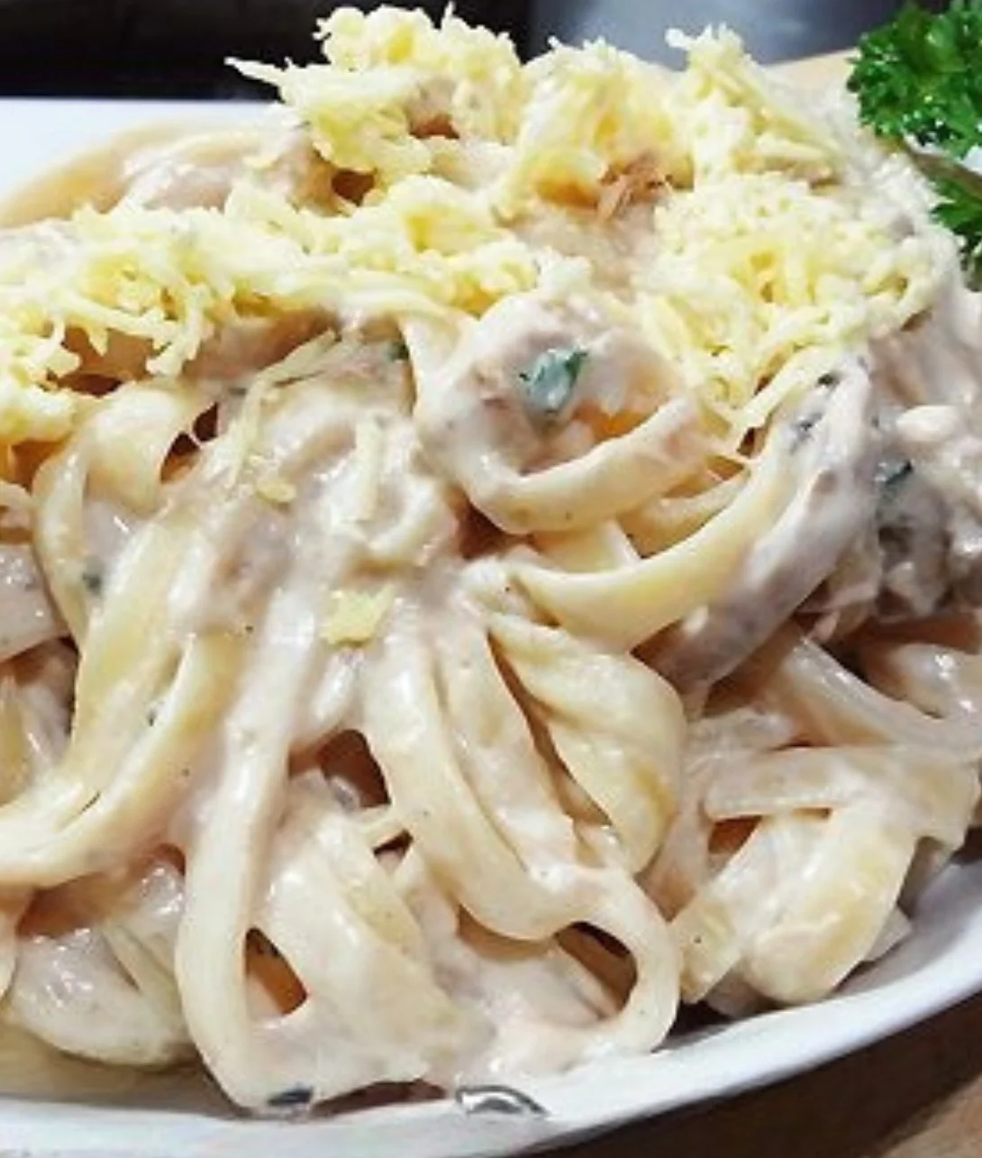 Creamy tuna carbonara dish garnished with parsley