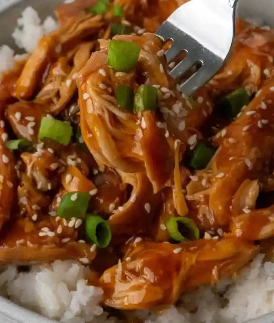 Delicious Crockpot Huli Huli Chicken served on a plate with pineapple and green onions.