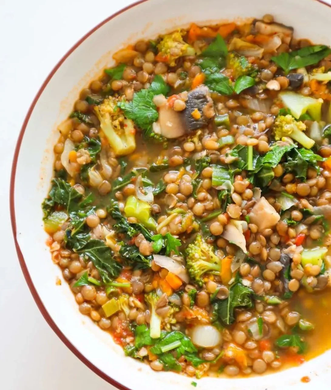 Bowl of easy lentil vegetable soup with fresh vegetables and herbs