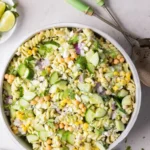 A vibrant bowl of cilantro lime pasta salad with fresh vegetables and lime dressing