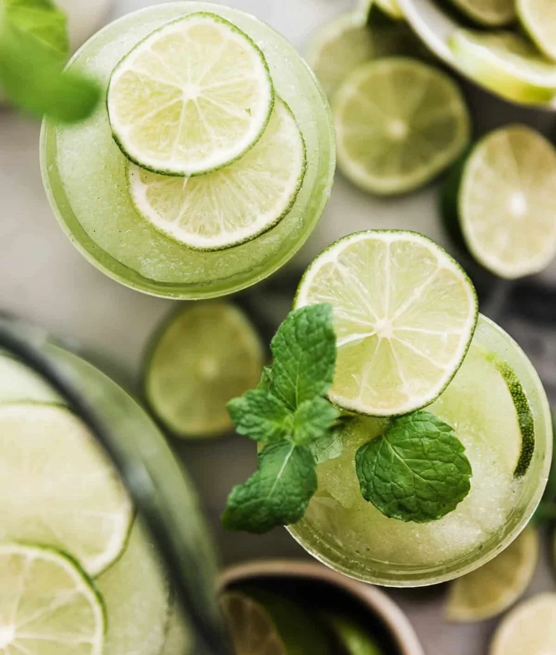 Frozen Mojito Mocktail in a glass garnished with mint leaves and lime slices.