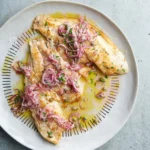 Delicious grilled fish served with caper and red onion dressing for a flavorful dish