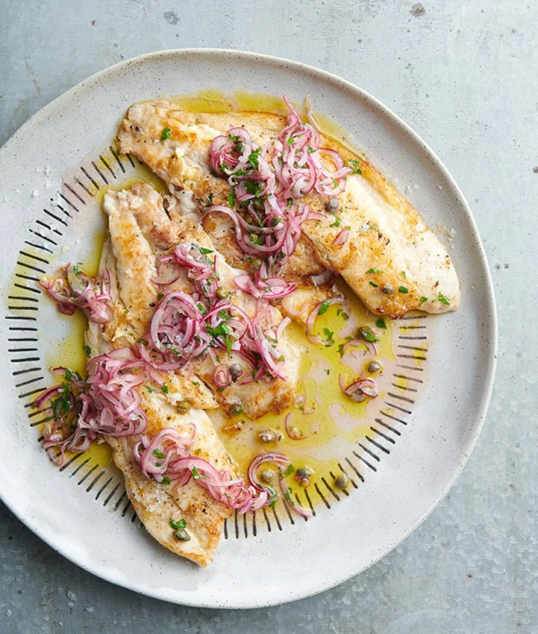Delicious grilled fish served with caper and red onion dressing for a flavorful dish