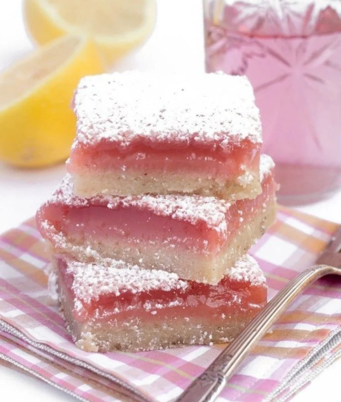 Hibiscus Lemon Bars with a vibrant pink hue and lemon zest drizzle