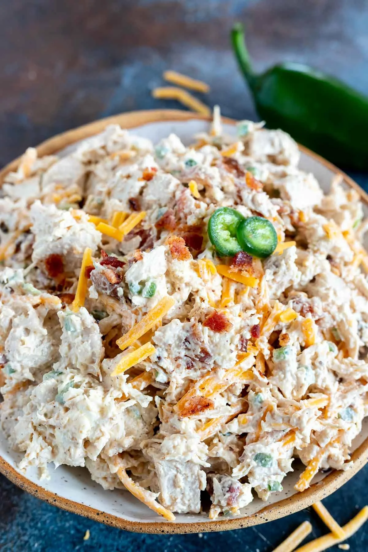Plate of Jalapeño Popper Chicken Salad topped with jalapeños and cheese