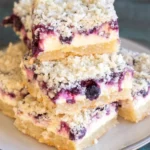 Keto blueberry lemon cheesecake bars topped with fresh blueberries