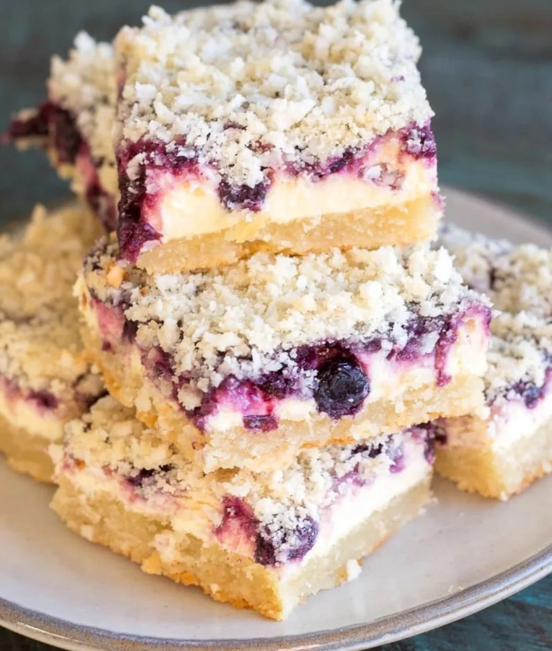 Keto blueberry lemon cheesecake bars topped with fresh blueberries