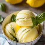 Refreshing Lemon Basil Sorbet served in a bowl with fresh basil leaves.