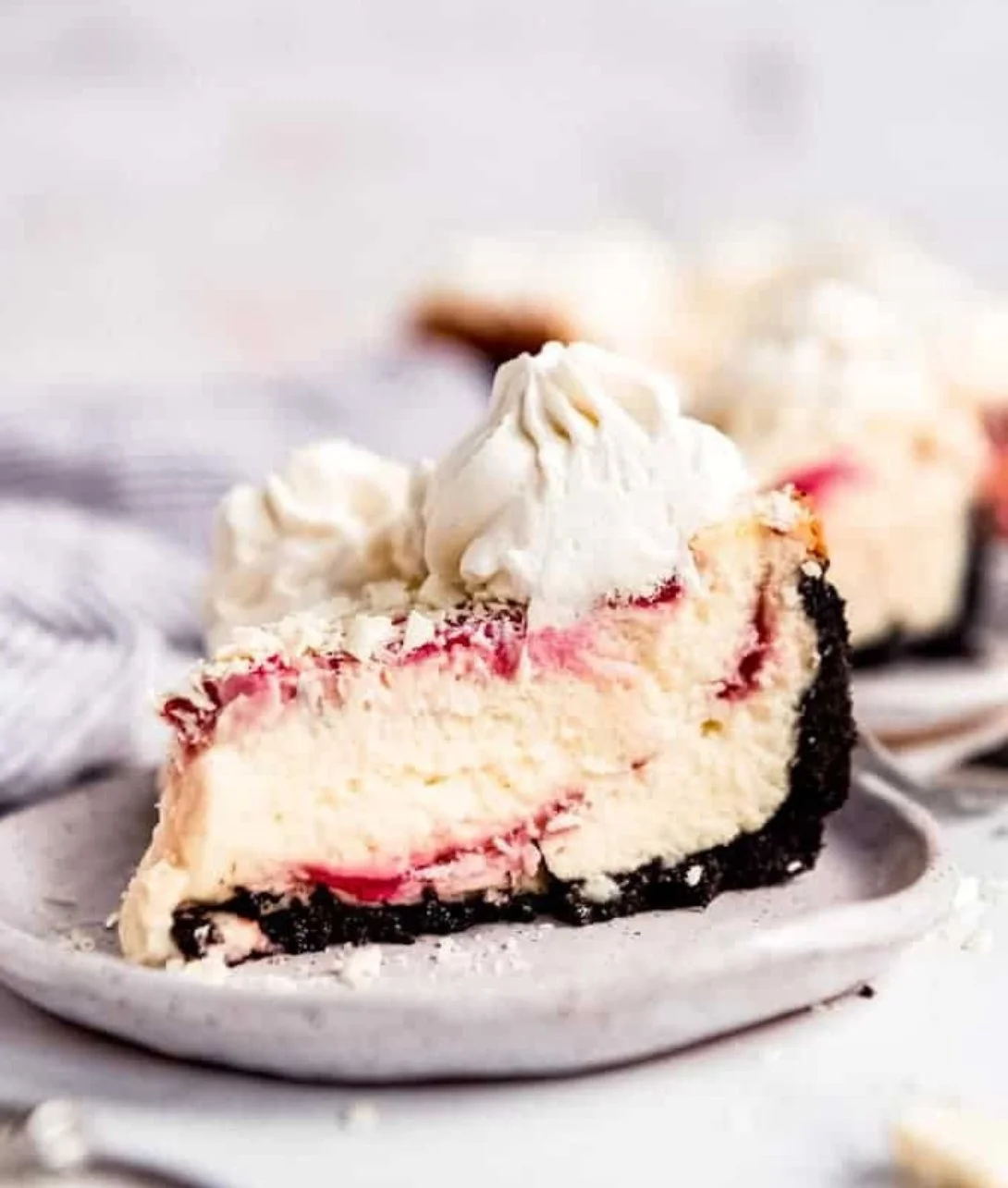 Slice of Raspberry White Chocolate Cheesecake with fresh raspberries on top