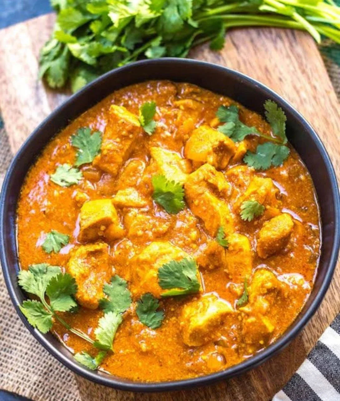 Slow Cooker Chicken Tikka Masala served in a bowl with naan bread.