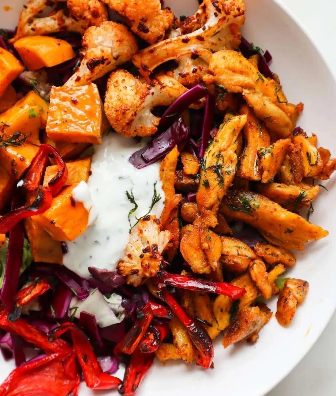 Bowl of spicy chicken and roasted vegetables for a healthy meal