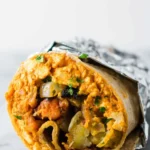 Delicious vegan breakfast burrito filled with fresh veggies and spices