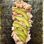 Tuna salad nori wraps filled with fresh ingredients and garnished with herbs.