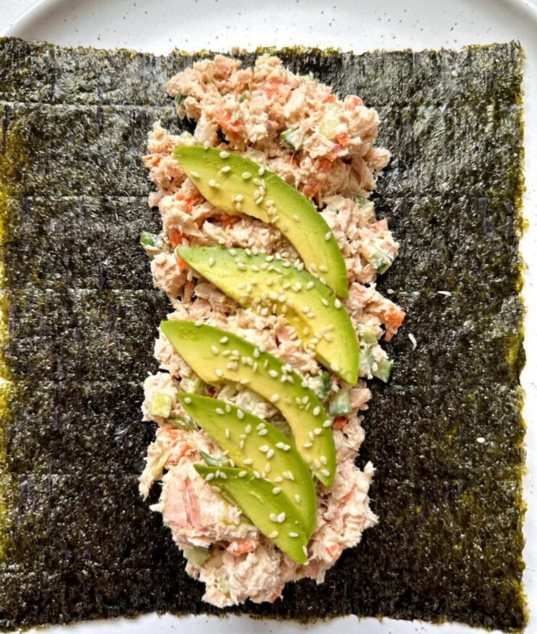 Tuna salad nori wraps filled with fresh ingredients and garnished with herbs.