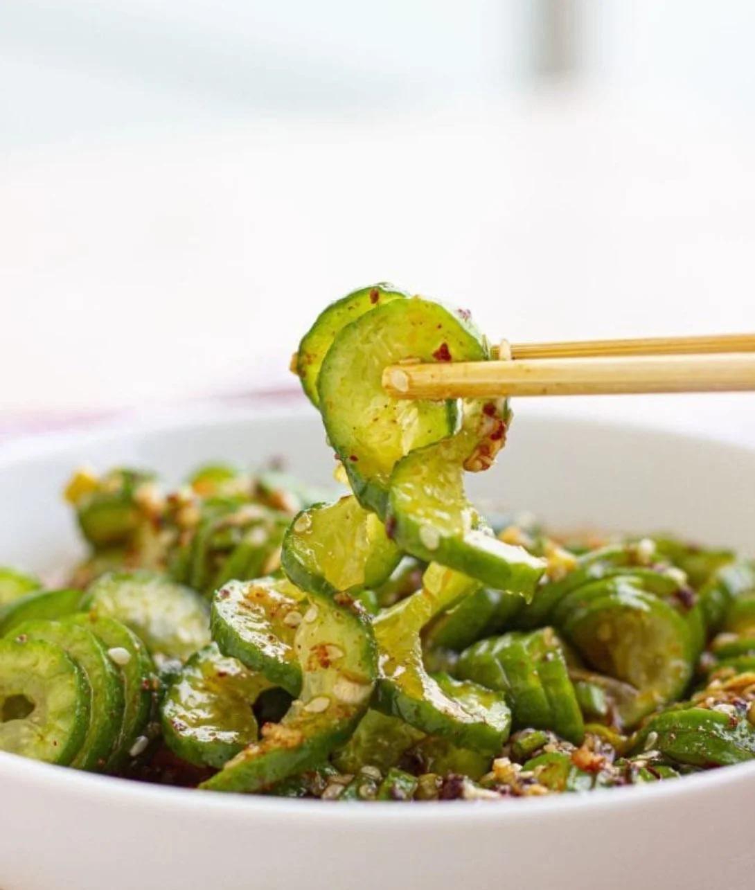 Bowl of vibrant viral Asian cucumber salad with fresh herbs and dressing