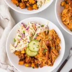 BBQ chicken bowls with sweet potatoes and coleslaw served in a vibrant dish