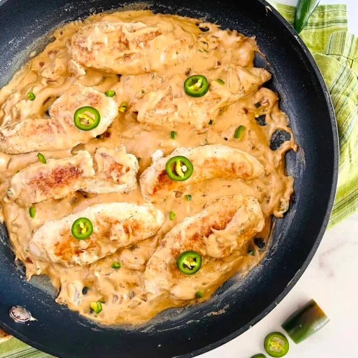 Cheesy jalapeño chicken dish garnished with fresh herbs
