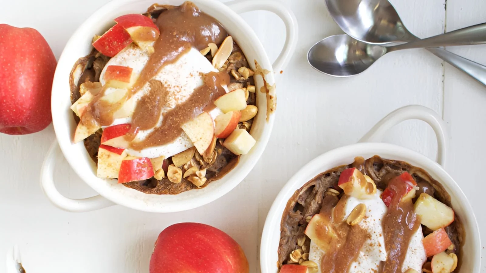 Creamy apple baked oatmeal in a bowl garnished with fresh apple slices and cinnamon.