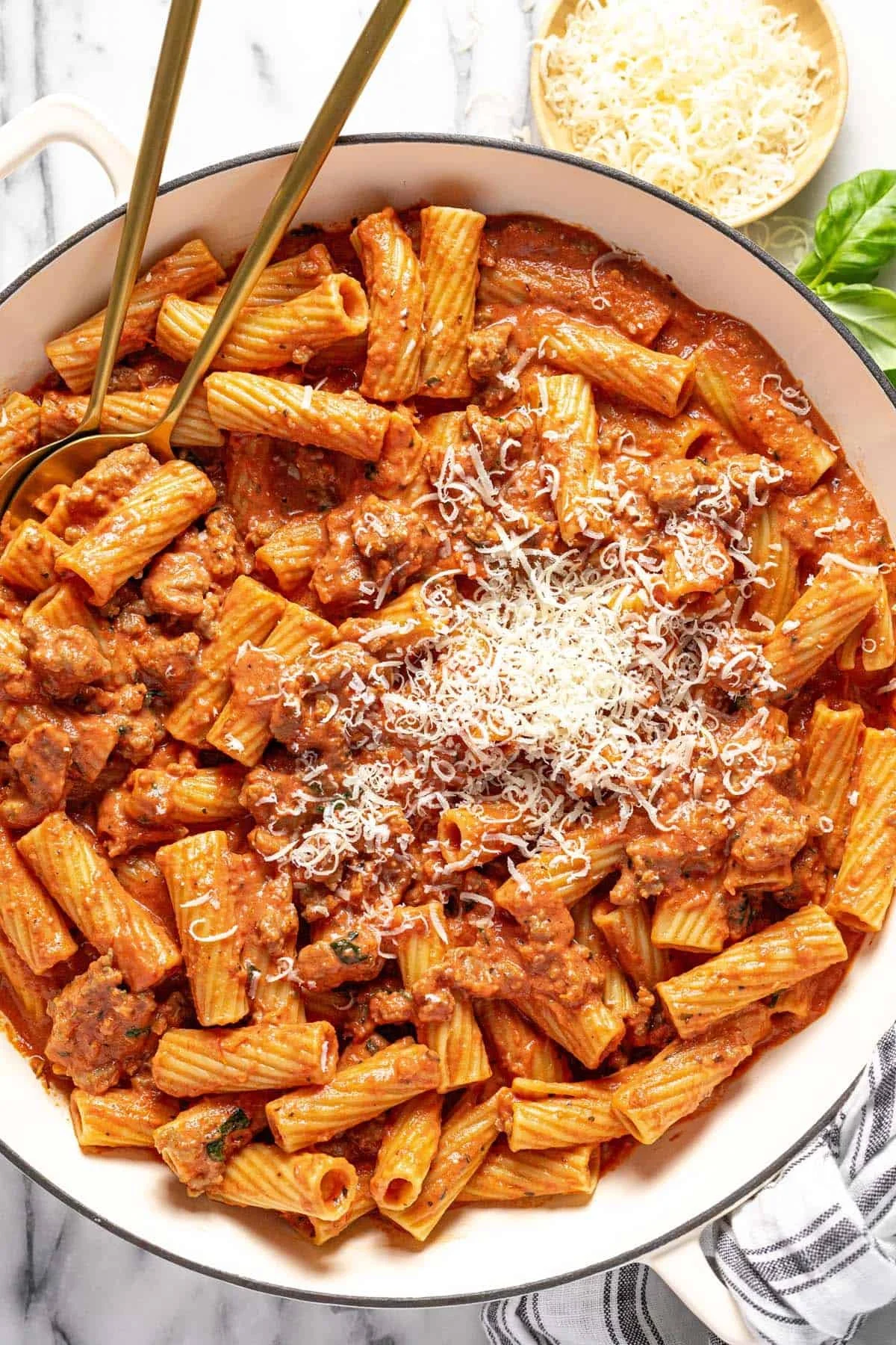 Creamy sausage rigatoni pasta topped with herbs and cheese