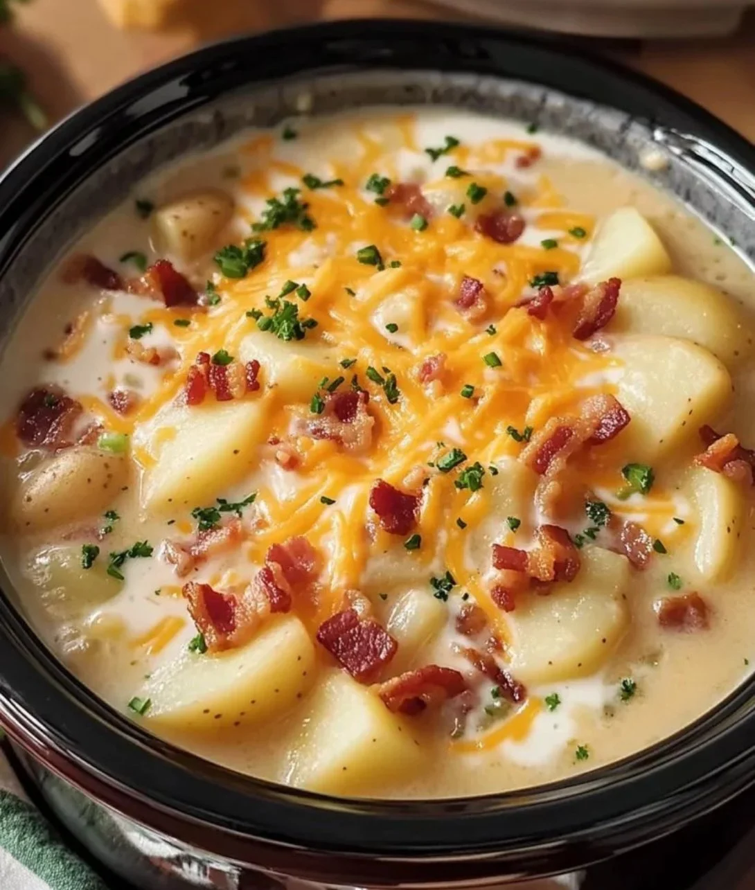 Bowl of creamy Crock Pot Crack Potato Soup topped with green onions and cheese