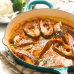 Delicious Curry Fish served in a bowl with vibrant spices and herbs.