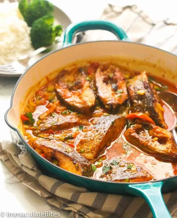 Delicious Curry Fish served in a bowl with vibrant spices and herbs.
