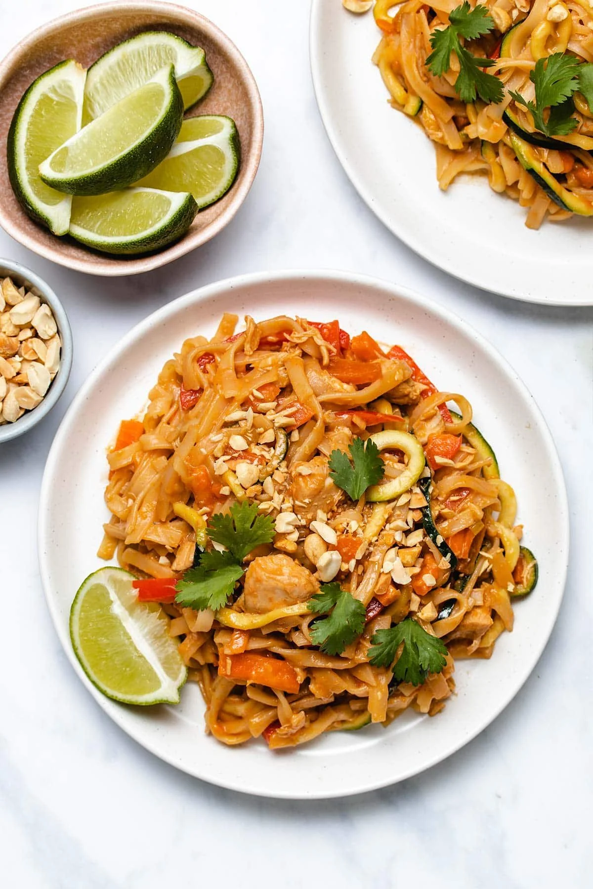 Delicious Instant Pot Chicken Pad Thai served in a bowl with fresh herbs.