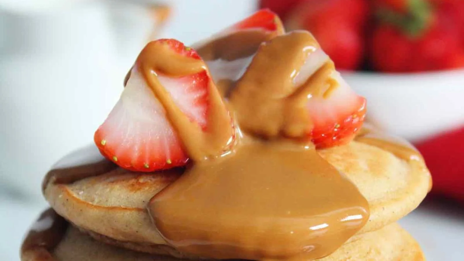 Fluffy Lotus Biscoff pancakes topped with syrup and crushed Biscoff cookies