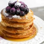 Delicious mini silver dollar pancakes served with syrup and fresh fruit