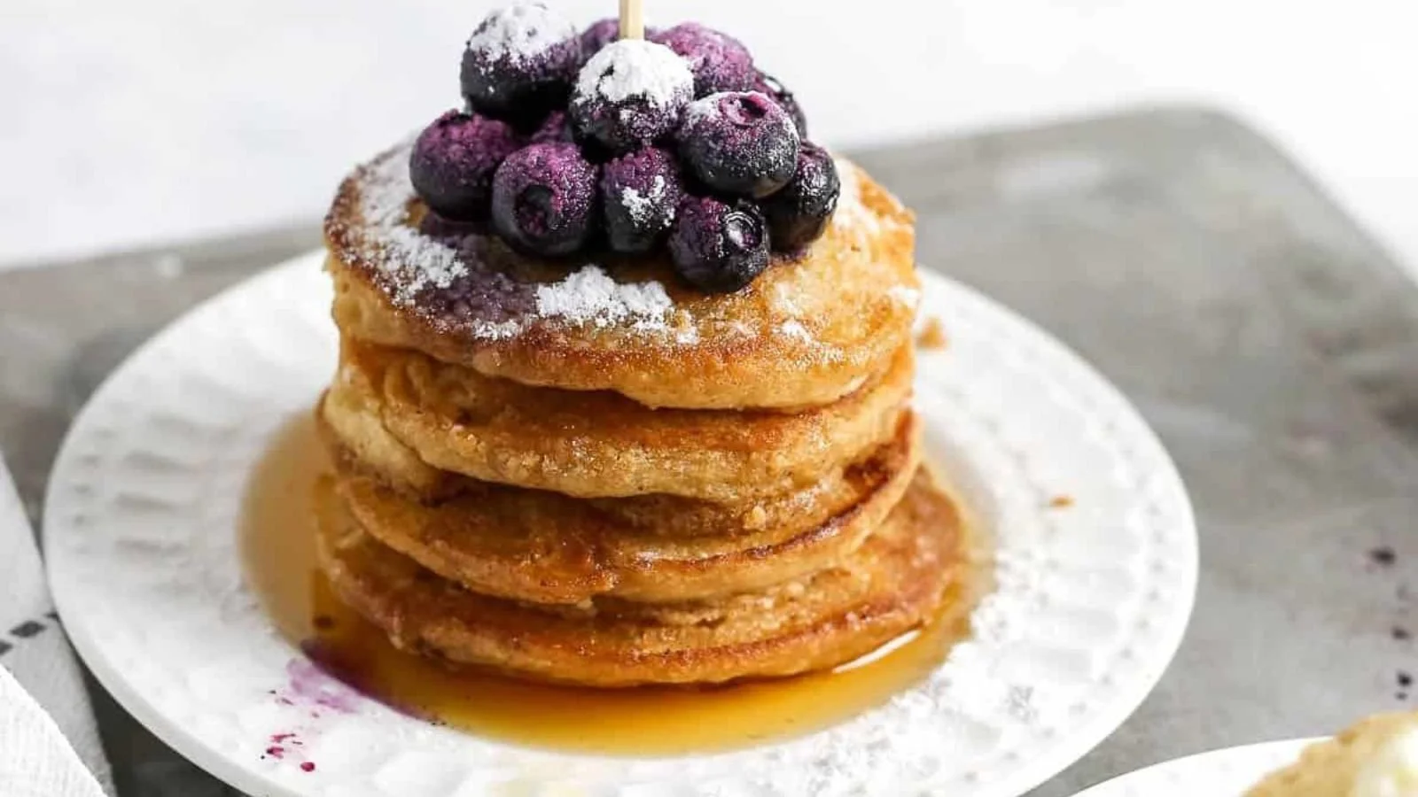 Delicious mini silver dollar pancakes served with syrup and fresh fruit