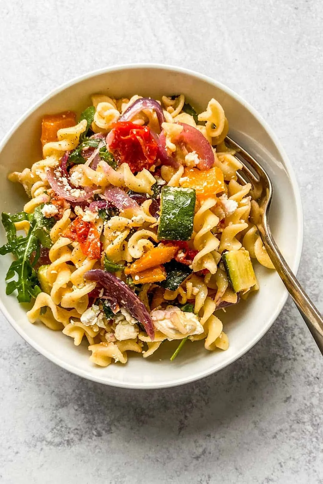 Delicious roasted veggie pasta with feta cheese served in a bowl