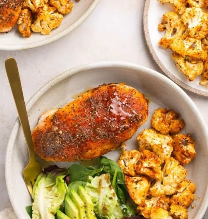 Sheet pan honey garlic baked chicken with roasted cauliflower and vegetables.