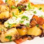 Delicious breakfast hash with potatoes, eggs, and vegetables in a skillet.