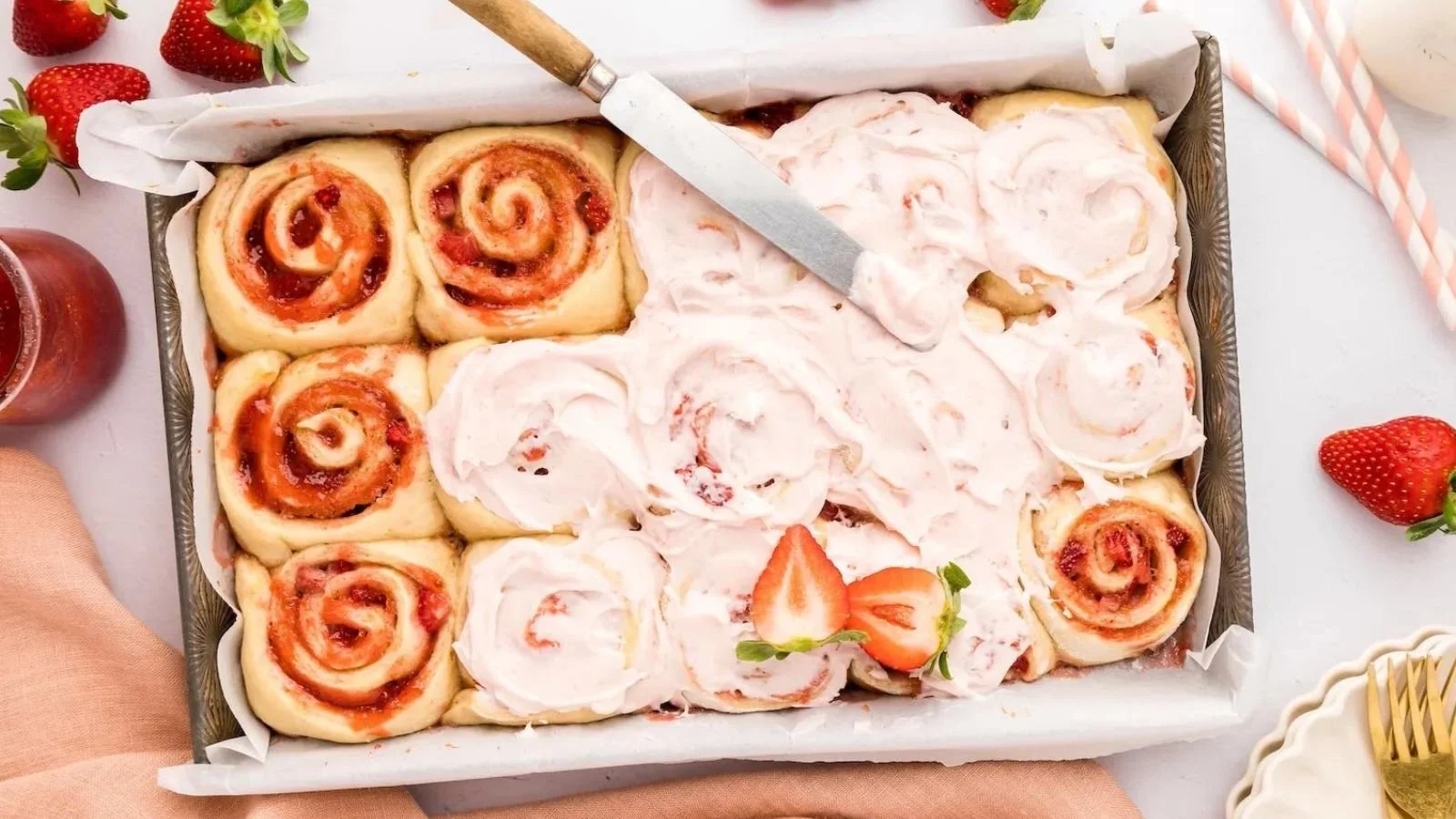 Freshly baked Strawberry Cinnamon Rolls topped with icing and strawberries