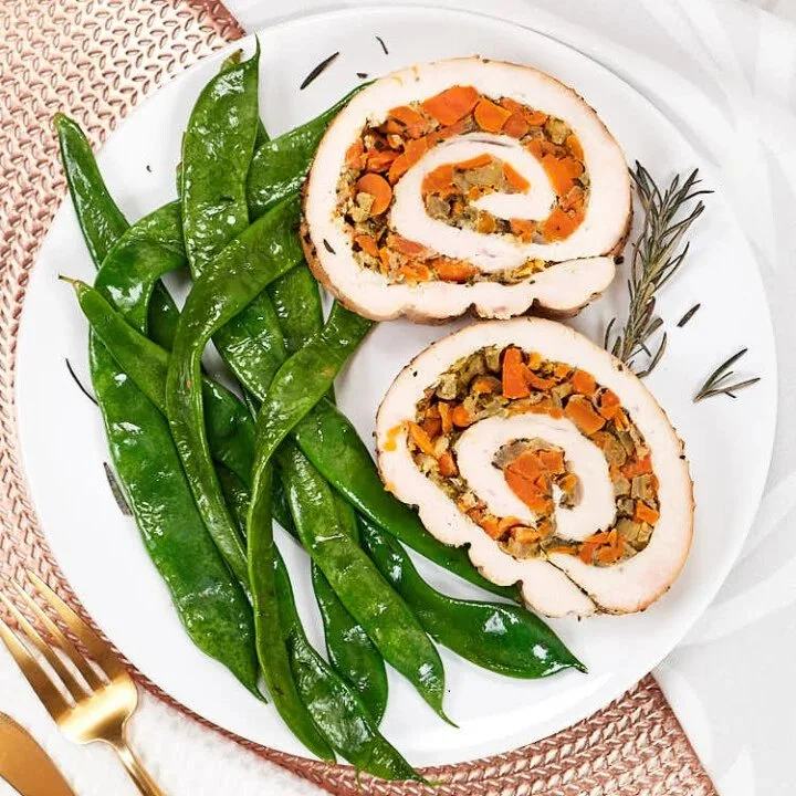 Deliciously rolled Turkey Roulade with herbs and spices, served on a platter.